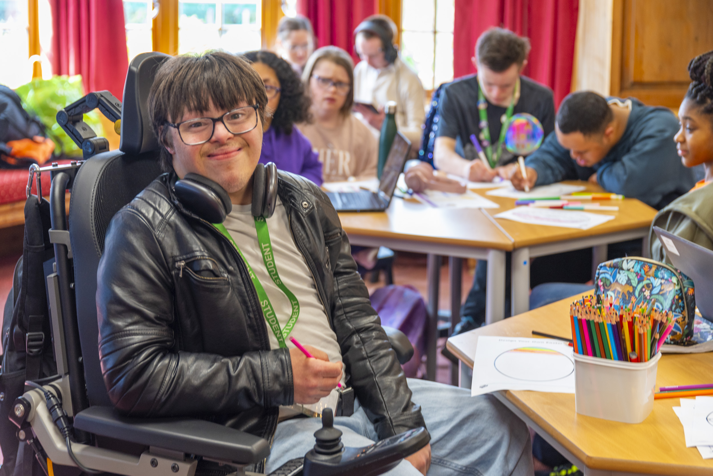 Students in class, Student in wheelchair facing the camera smiling