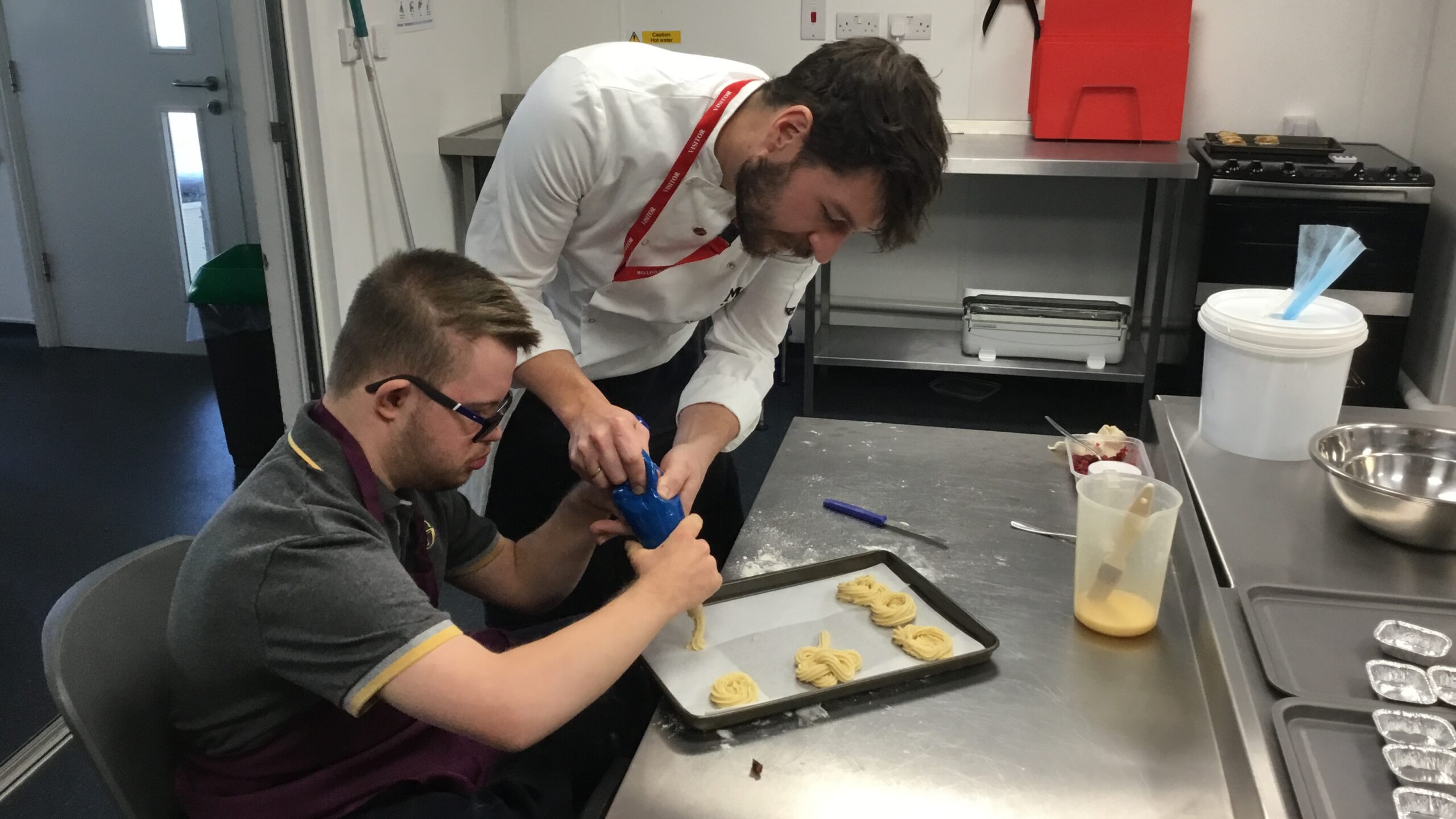 Student working alongside a corporate partner volunteering their time to teach new skills